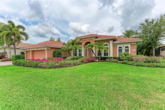 mediterranean / spanish-style house with a front lawn and a garage