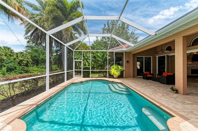 view of pool featuring a lanai, ceiling fan, outdoor lounge area, and a patio