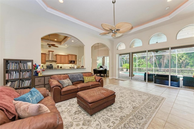 tiled living room featuring a raised ceiling and crown molding