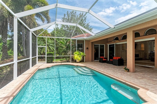 view of pool with glass enclosure, an outdoor hangout area, ceiling fan, and a patio