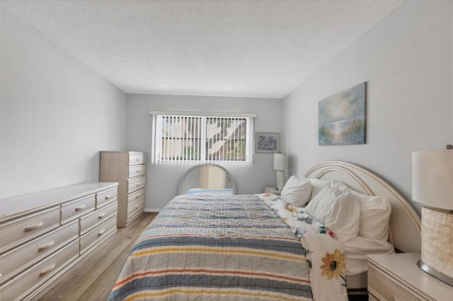 bedroom with a textured ceiling and wood-type flooring