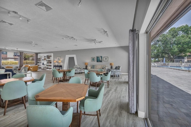 dining area with ceiling fan, a textured ceiling, and light hardwood / wood-style floors