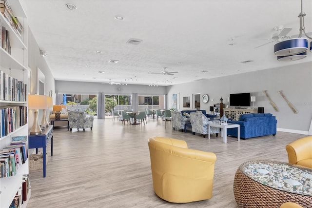 living room featuring ceiling fan and light wood-type flooring