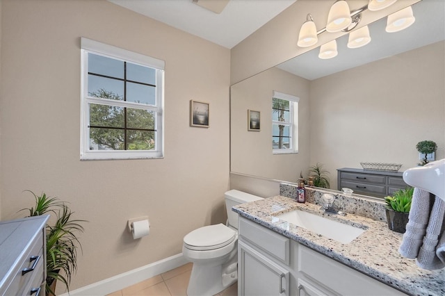 bathroom with tile patterned flooring, vanity, toilet, and plenty of natural light