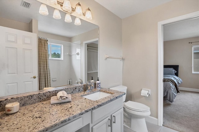 bathroom featuring tile patterned floors, vanity, toilet, and walk in shower