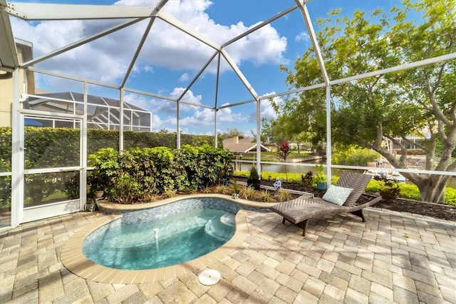 view of pool featuring glass enclosure, a patio area, and a water view