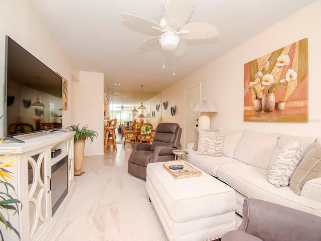 living room featuring ceiling fan and a textured ceiling