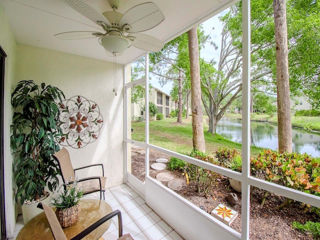 sunroom featuring a water view and ceiling fan