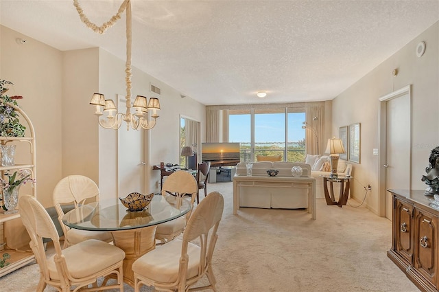 dining area featuring a textured ceiling, light carpet, and an inviting chandelier