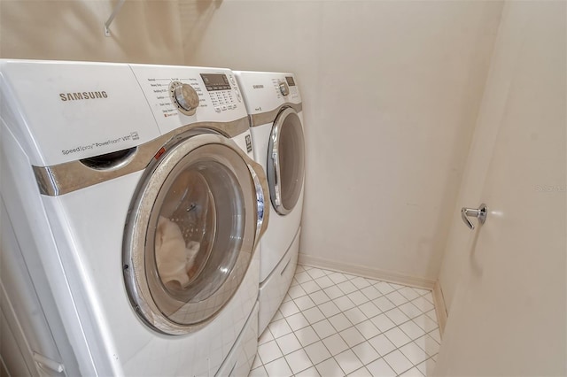 laundry room with light tile floors and washer and clothes dryer