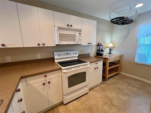 kitchen with white appliances, white cabinetry, and light tile floors