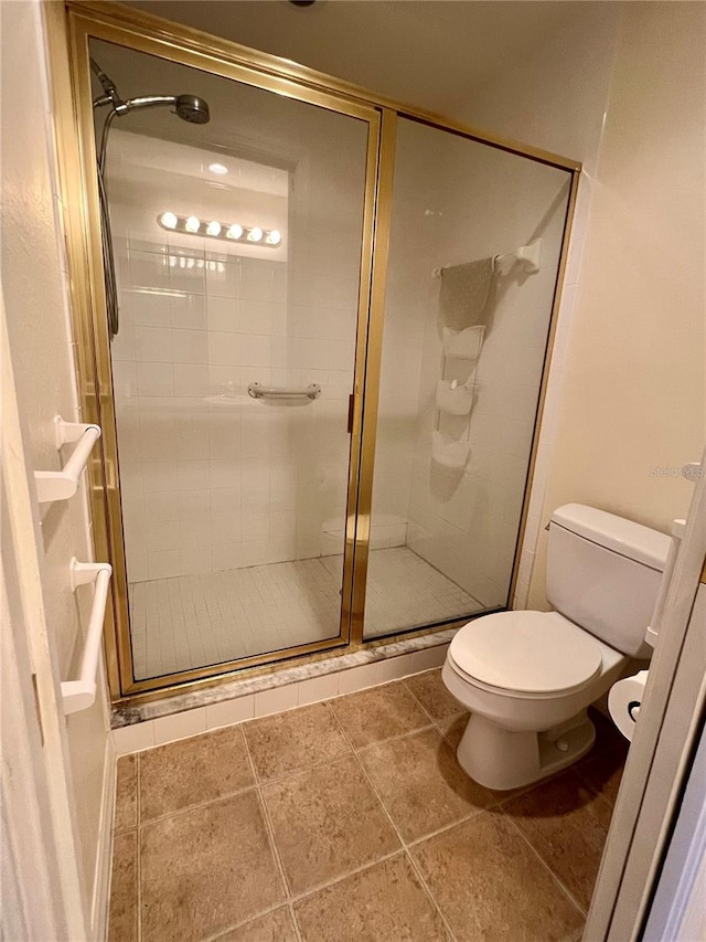 bathroom with tile flooring, toilet, and an enclosed shower