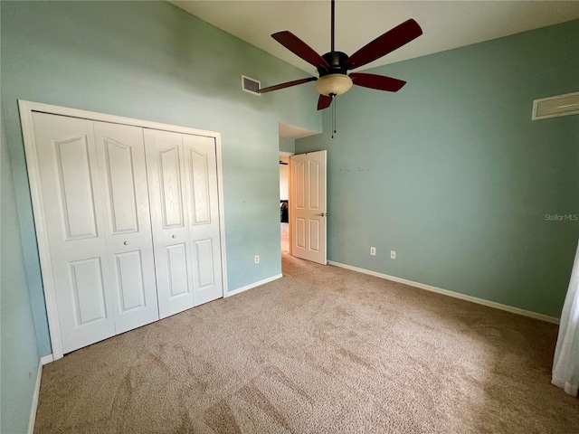 unfurnished bedroom featuring ceiling fan, a closet, and light carpet