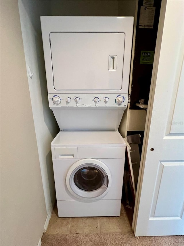 washroom featuring stacked washer and clothes dryer and light tile floors