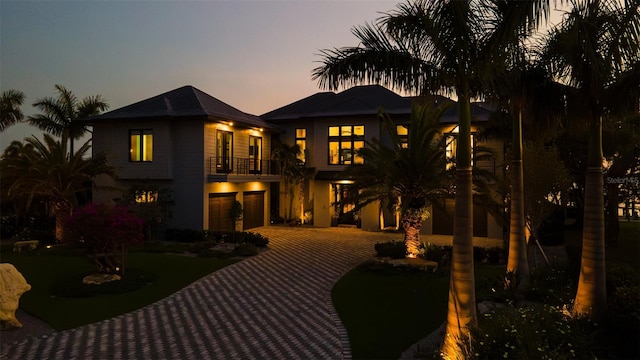 back house at dusk featuring a balcony