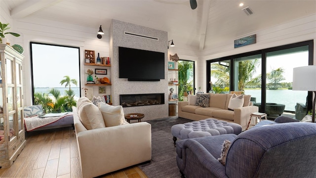 living room featuring wood ceiling, wooden walls, lofted ceiling with beams, a fireplace, and hardwood / wood-style floors