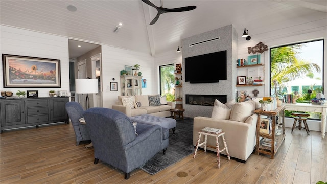 living room with a healthy amount of sunlight, ceiling fan, a fireplace, and wood-type flooring