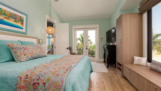 bedroom featuring french doors, access to outside, light hardwood / wood-style flooring, and lofted ceiling