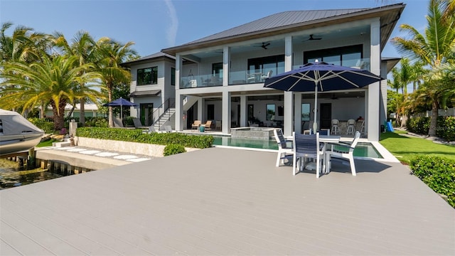 rear view of property with a patio, a balcony, and ceiling fan