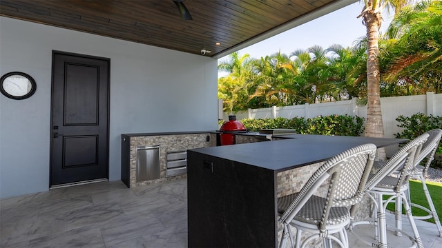 view of patio with ceiling fan and exterior bar