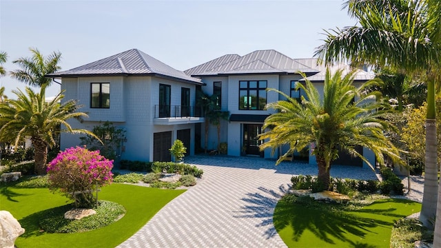 view of front of house with a balcony and a front lawn