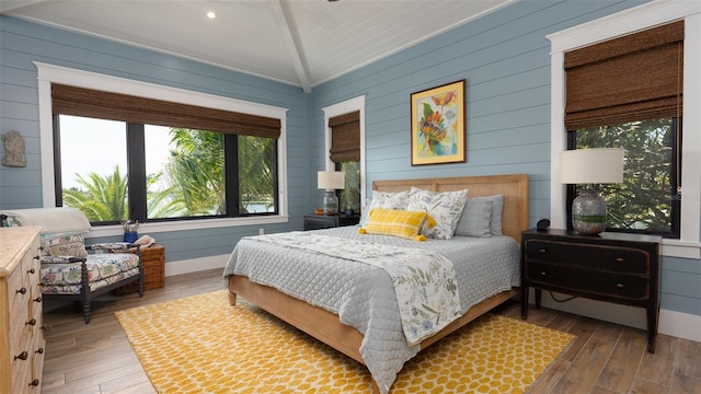 bedroom with wood-type flooring and vaulted ceiling