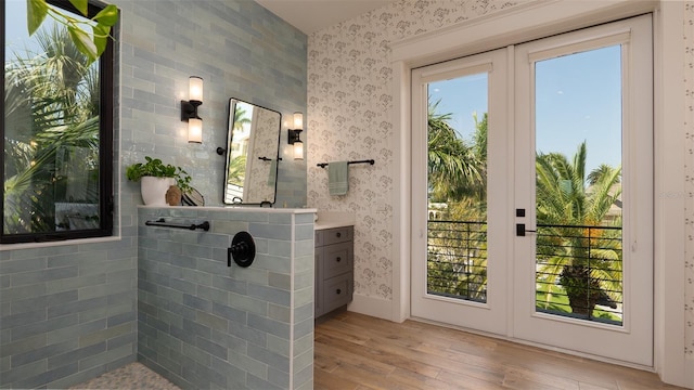 bathroom featuring a shower, wood-type flooring, vanity, and a healthy amount of sunlight