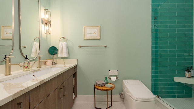 bathroom featuring a tile shower, tile patterned floors, vanity, and toilet