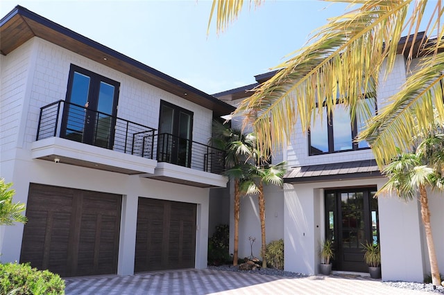 view of front of property featuring a garage and a balcony