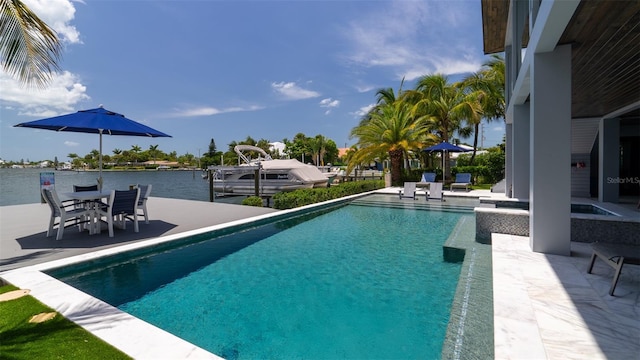 view of pool featuring a boat dock, a water view, and a patio area