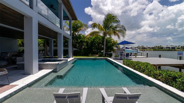 view of swimming pool with an in ground hot tub, a patio, a water view, and a dock