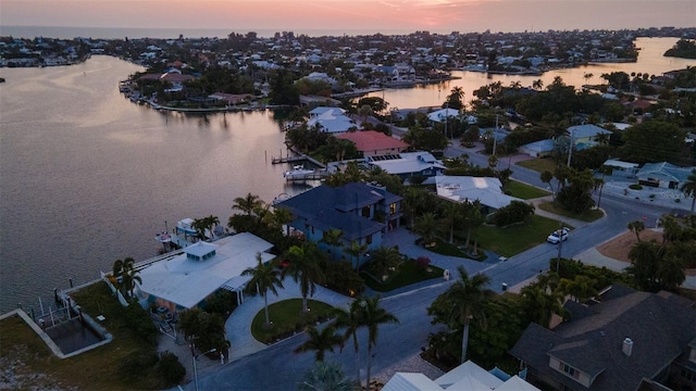 aerial view at dusk featuring a water view