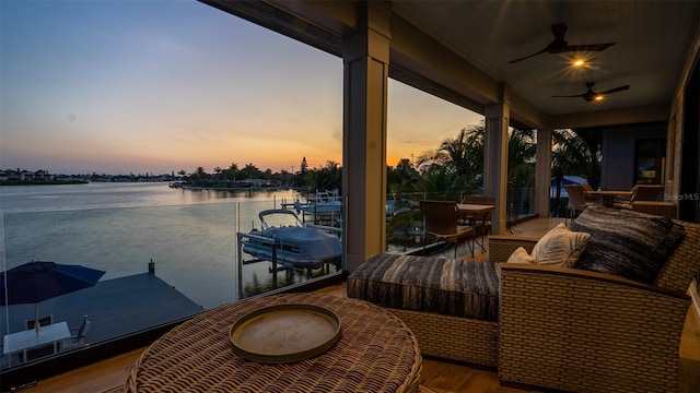 exterior space with a water view, a dock, and ceiling fan