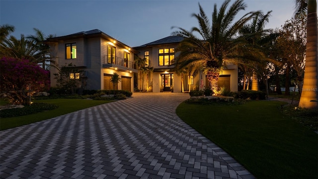 view of front of home featuring a yard and a balcony