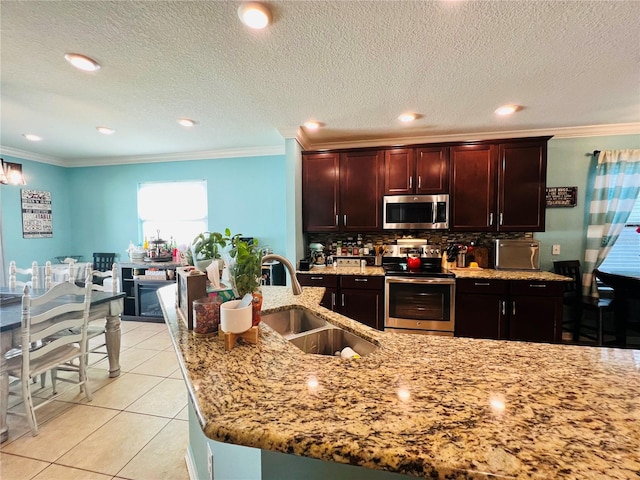 kitchen with appliances with stainless steel finishes, sink, crown molding, and light tile flooring