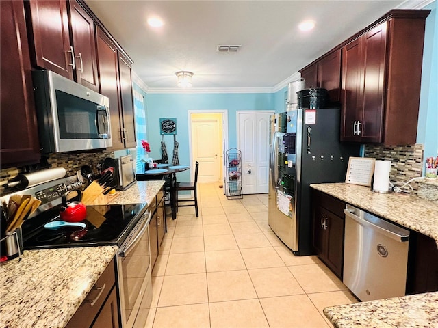 kitchen with light tile floors, backsplash, crown molding, stainless steel appliances, and light stone countertops