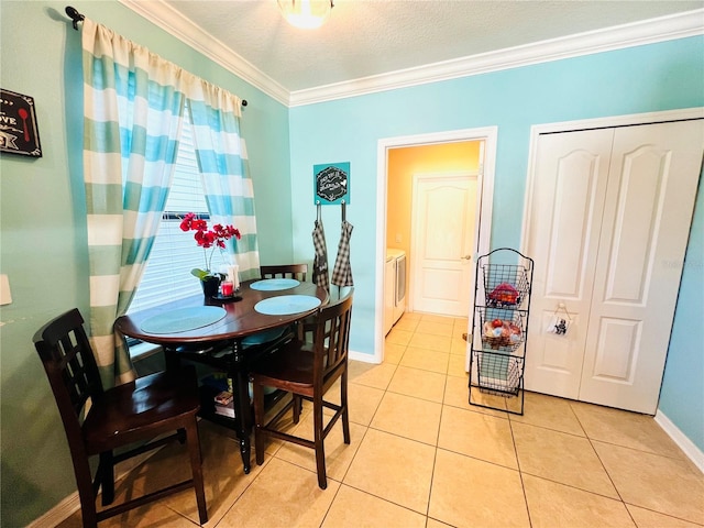 tiled dining area featuring a textured ceiling, crown molding, and washer / dryer