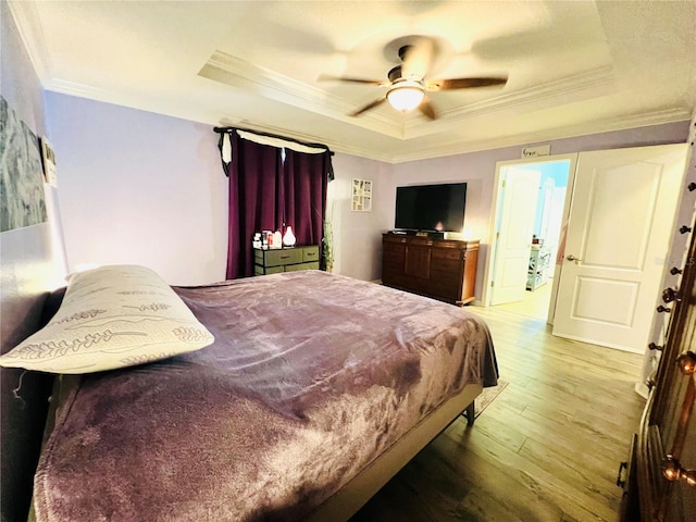 bedroom featuring ceiling fan, a tray ceiling, hardwood / wood-style flooring, and crown molding