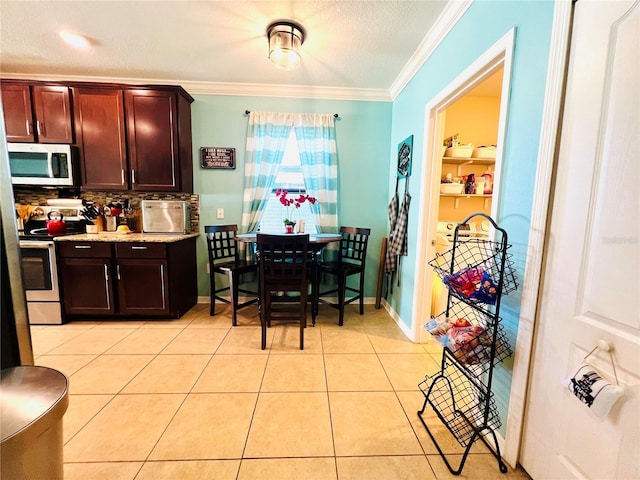 kitchen with appliances with stainless steel finishes, a textured ceiling, light tile flooring, backsplash, and crown molding