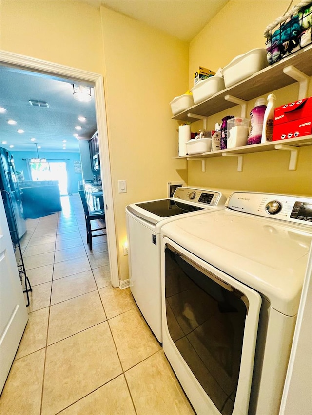 washroom featuring light tile flooring and washer and dryer