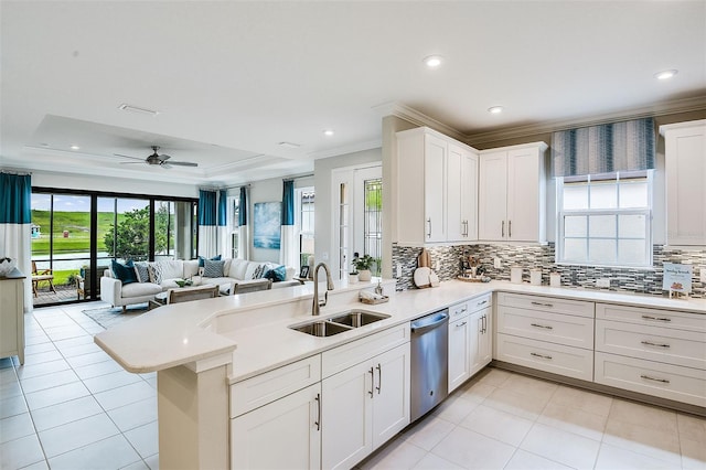 kitchen with kitchen peninsula, sink, stainless steel dishwasher, ceiling fan, and white cabinetry