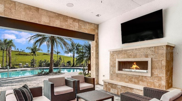 view of patio with an outdoor stone fireplace and a rural view