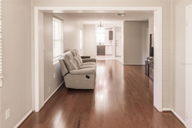 living area with a chandelier and dark wood-type flooring