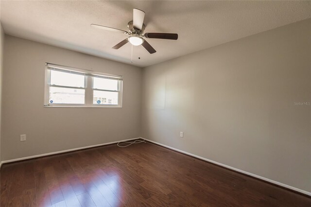 unfurnished room with dark wood-type flooring and ceiling fan