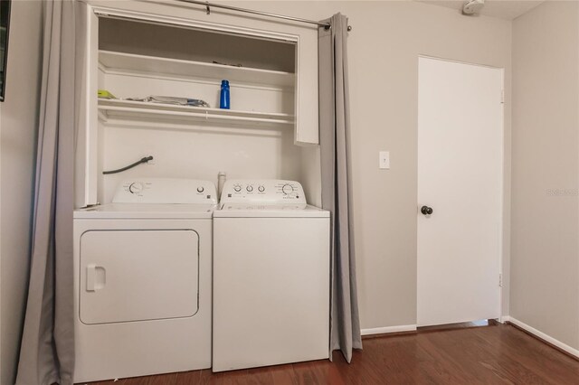 clothes washing area with dark hardwood / wood-style flooring and washing machine and dryer