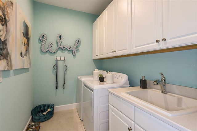 washroom with washing machine and clothes dryer, light tile patterned floors, cabinets, and sink