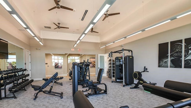 workout area featuring ceiling fan, carpet floors, and a towering ceiling