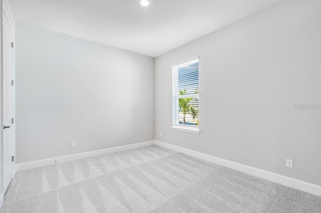 unfurnished room featuring light carpet