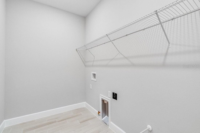 clothes washing area with hookup for a washing machine, hookup for a gas dryer, and light hardwood / wood-style floors