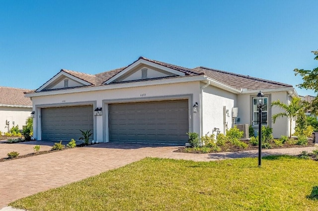 ranch-style house with a garage, cooling unit, and a front lawn